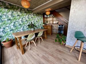 a dining room with a table and chairs and plants at Victoria Ocean View Room in Ponta do Pargo