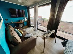 a living room with a couch and a large window at Victoria Ocean View Room in Ponta do Pargo