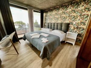 um quarto com uma cama com uma parede floral em Victoria Ocean View Room em Ponta do Pargo