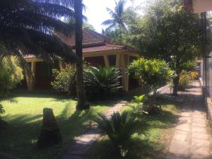 una casa con palmeras delante en Sítio dos Guedes, en Guapimirim