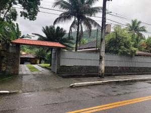 una calle vacía al lado de un edificio con una palmera en Sítio dos Guedes en Guapimirim