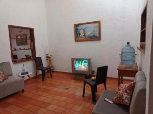 a living room with a couch and a tv at Casa Bautan in Barichara