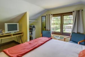 een slaapkamer met een bed en 2 stoelen en een televisie bij Covington Vacation Rental with Private Yard in Covington