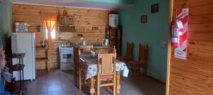 Aires del Montura في أوسبالاتا: مطبخ وغرفة معيشة مع طاولة وثلاجة