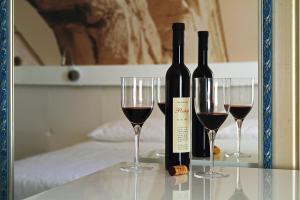 zwei Flaschen Wein und zwei Gläser auf dem Tisch. in der Unterkunft La Porta Luxury Rooms in Split