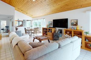 a living room with a large couch and a tv at Good Fortune in McKinleyville