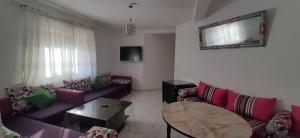 a living room with purple couches and a table at RESIDENCE AL Hoceima 2 Minutes de prés de PLAGE CALABONITA in Al Hoceïma