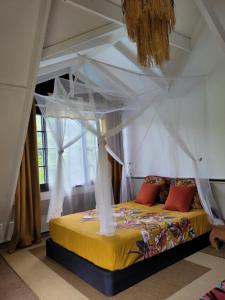 1 dormitorio con 1 cama con dosel en Fare Haurevaiti Moorea en Paopao
