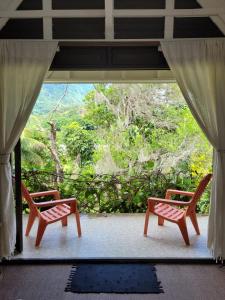 2 sillas sentadas en un porche con vistas en Fare Haurevaiti Moorea, en Paopao