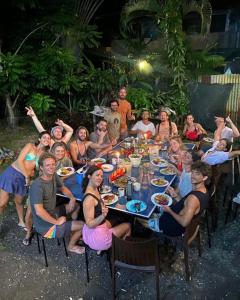 a group of people sitting around a table eating at Hostel Esperanza in Pavones