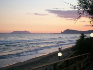 two people walking on the beach at sunset at Holiday Village in Fondi