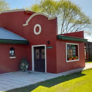 una casa roja con una puerta delante en La Cipriana en Concepción del Uruguay