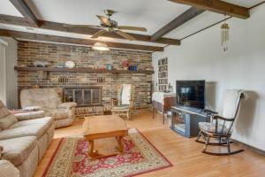 a living room with a brick fireplace and a ceiling fan at Gassville Home 3 Mi to White River and Trout Fishing in Gassville