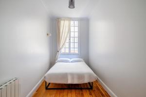 パリにあるLuxury Living à Montorgueilの窓付きの客室の小さなベッド1台分です。