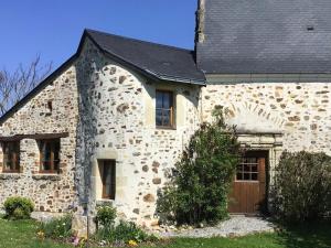 Souvigné-sur-Sarthe的住宿－Gîte Souvigné-sur-Sarthe, 3 pièces, 5 personnes - FR-1-410-191，一座石头房子,设有黑色屋顶和车库