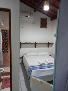 um quarto com uma cama num quarto com um espelho em Pousada do farol em Jericoacoara