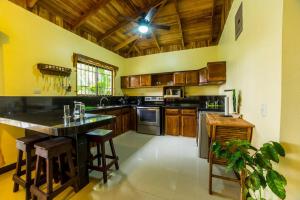 a kitchen with wooden cabinets and a ceiling fan at Arenal ginger home in Fortuna