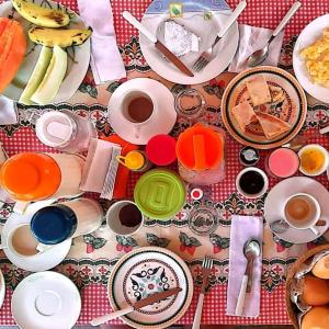 a table with plates of food and cups of coffee at Pousada do farol in Jericoacoara