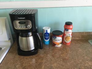 a coffee maker and condiments on a kitchen counter at Cozy Bay View OceanSide cottage in Willoughby Beach