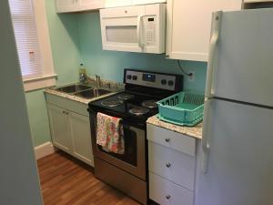 a kitchen with a stove and a sink and a refrigerator at Cozy Bay View OceanSide cottage in Willoughby Beach