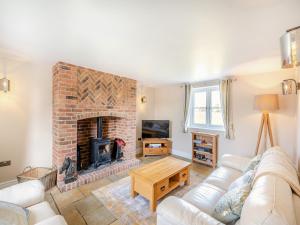 a living room with a couch and a fireplace at Horseshoe Cottage in Cottam