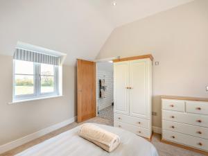 a white bedroom with a bed and a window at Horseshoe Cottage in Cottam