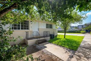 a house with a staircase in front of a yard at 3 BR Smart home, close to airport, Fast WiFi, Patio, Grill & Free private parking in Miami
