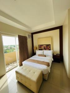 a bedroom with a large bed and a large window at Sierra Hotel in Dumaguete