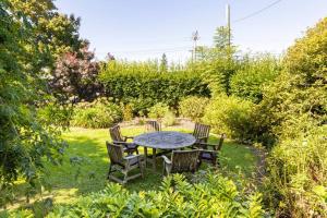 a table and chairs in a garden with a table and chairs at History @ Renall in Masterton