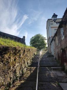 una vía de tren junto a una pared de piedra junto a un edificio en Pleno Casco Vello, Céntrico, Reformado 2023, en Vigo