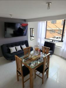 sala de estar con mesa, sillas y sofá en Moderno y Amplio Apartamento en Medellín