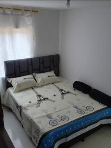 Un dormitorio con una cama con una manta. en Moderno y Amplio Apartamento en Medellín