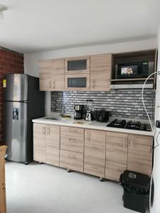 cocina con armarios de madera y nevera de acero inoxidable en Moderno y Amplio Apartamento en Medellín