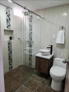 y baño con aseo, lavabo y ducha. en Moderno y Amplio Apartamento en Medellín