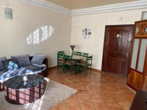 een woonkamer met een bank en een tafel bij Appartement propre et calme in Casablanca