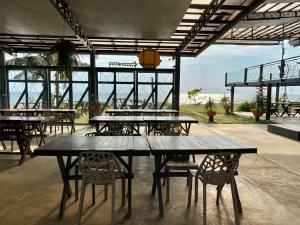 a group of tables and chairs in a building at Chanchaolao Beach Resort in Chao Lao Beach