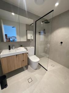 a bathroom with a toilet and a sink and a shower at Heart Of Fremantle New Chic Spacious 2 Bed 2 Bath Apartment Very Comfortable, Well Equiped, Great location-Walk to shops restaurants, Bars & Markets 1 King 1 Queen in Fremantle