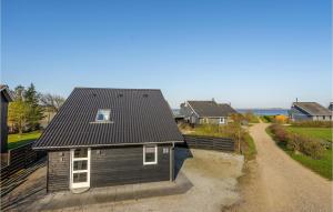 a house with a black roof on a dirt road at 2 Bedroom Lovely Home In Hemmet in Hemmet