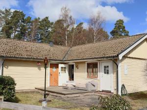 een klein wit huis met een veranda en een deur bij Holiday home BÅSTAD in Båstad