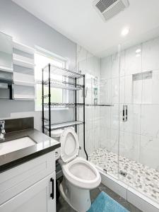 a white bathroom with a toilet and a shower at Spacious 4BR 4BA in Hollywood - Ful-WH in Los Angeles