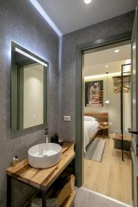 een badkamer met een wastafel, een bed en een spiegel bij Elegance Boutique Hotel in Korçë