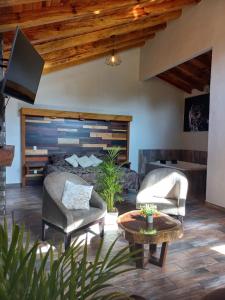 Sala de estar con 1 cama, 2 sillas y mesa en Cabañas Santorito, en Mazamitla