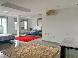 a living room with two beds and a red rug at Casa Aurora Luz do Amanhecer in Rio de Janeiro +92 photos