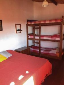 a bedroom with two bunk beds and a red blanket at Casa grande,3 min a pé do Centro, grupos, familias in Paraty