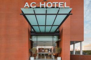una señal de hotel en el lateral de un edificio de ladrillo en AC Hotel Alcalá de Henares by Marriott, en Alcalá de Henares