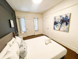 een kamer met een bed en een schilderij aan de muur bij Peaceful 2 Bedroom Home - NH-WIN in Los Angeles