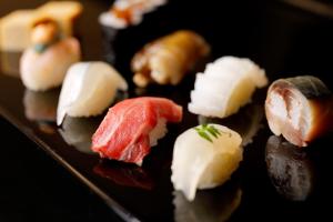 a bunch of sushi on a black plate at Hotel Nikko Kanazawa in Kanazawa