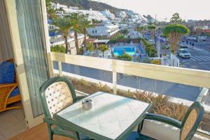 a table and chairs on a balcony with a view of a city at Lufesa in Puerto Rico de Gran Canaria