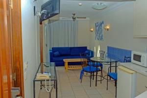 a living room with a blue couch and a table and chairs at Lufesa in Puerto Rico de Gran Canaria