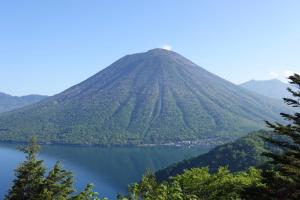a mountain with a lake in front of it at Hatago Nagomi in Nikko